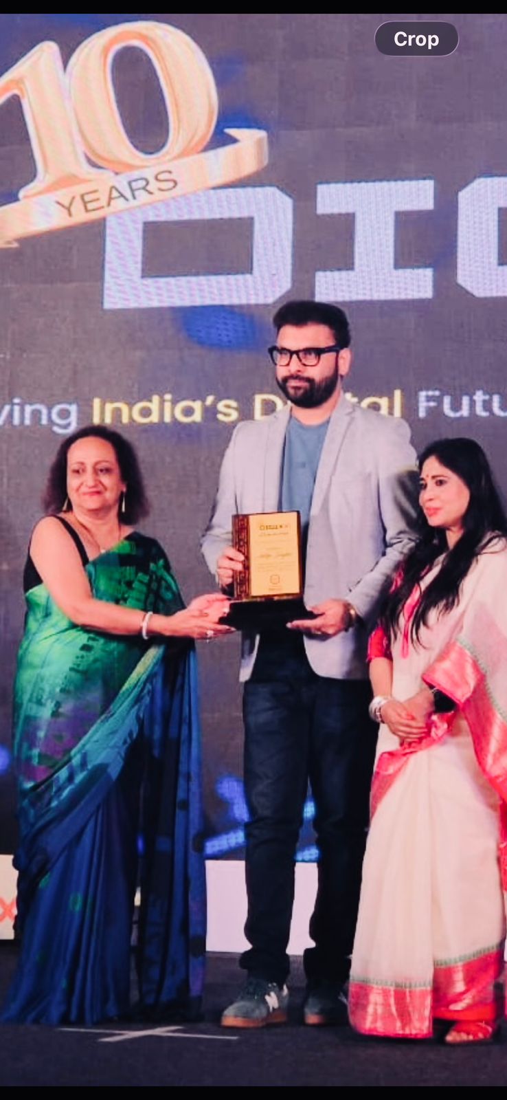 Aditya Singhal receiving DigiXX 10 Years Luminaries plaque on stage